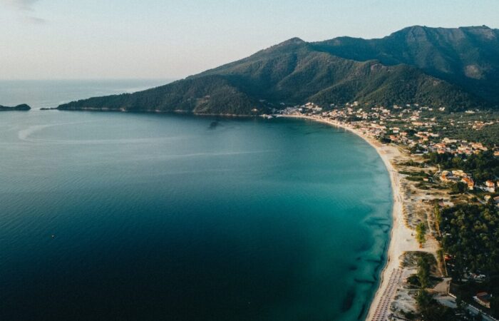 aerial view of green mountain beside body of water during daytime