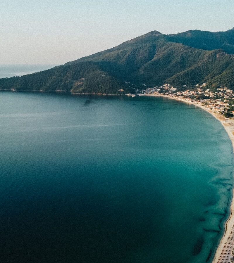 aerial view of green mountain beside body of water during daytime
